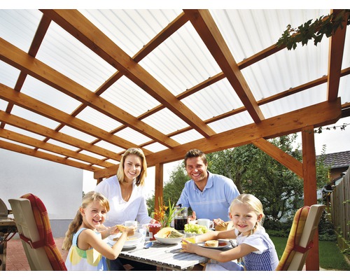 Gezin aan het eten onder een houten pergola met transparant dak