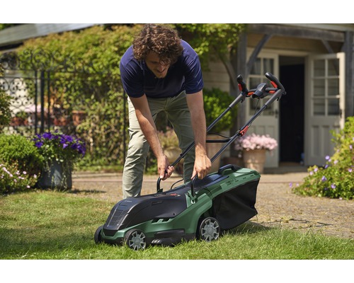 Een man gebruikt een Bosch grasmaaier in de tuin.