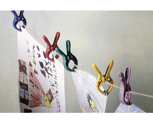 Kleurrijke wasknijpers houden kindertekeningen aan een waslijn