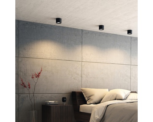 Slaapkamer met plafondlampen, bed en nachtkastje