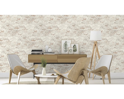 Woonkamer met vliesbehang in steenlook, houten tafel, staande lamp en stoelen.