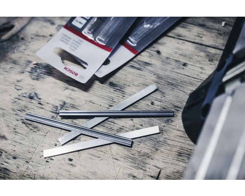 Bosch logo, schaafmessen en verpakking op een houten tafel