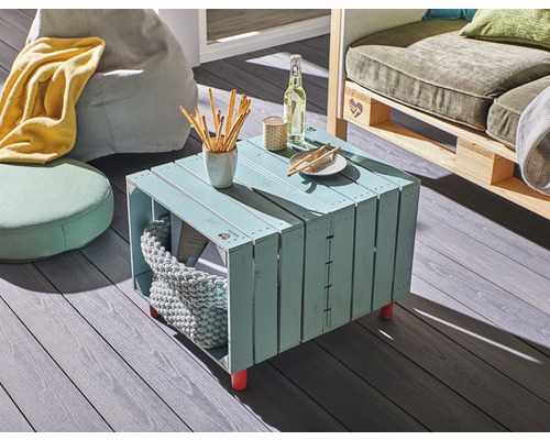 Woonkamer scène met houten kisttafel, zitzakken en palletbank