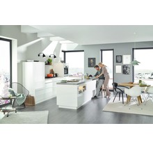 Lichte woonkamer met open keuken, eethoek en twee personen.
