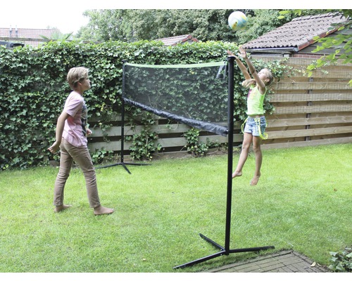 Twee kinderen spelen met een net in de tuin.