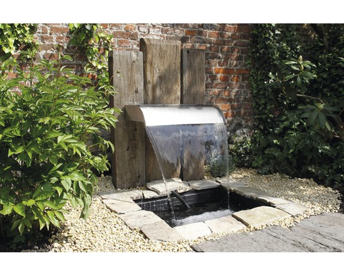 Tuinfontein met waterval, omgeven door planten en stenen