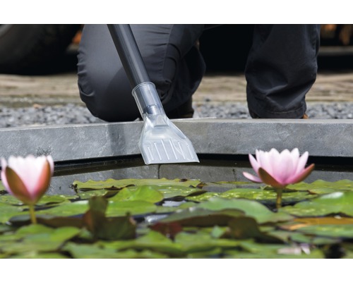 Vijverstofzuigermondstuk reinigt een vijver met waterlelies