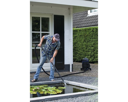Man maakt tuinvijver schoon met vijverslibzuiger