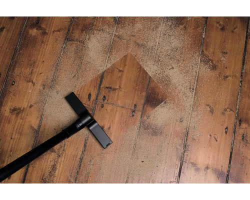 Stofzuiger hulpstuk op houten vloer met zand