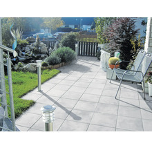 Terras met tuin, uitgerust met tuinmeubelen, tegels en buitenverlichting.