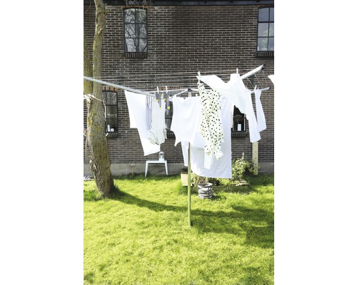 Waslijn in de tuin met opgehangen kleding voor een bakstenen gebouw