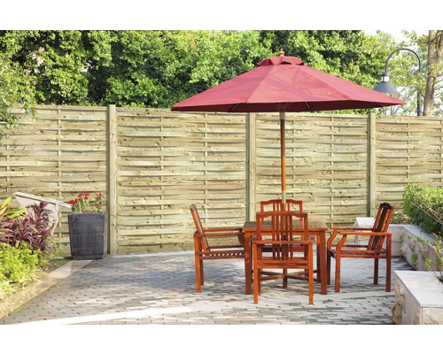 Tuinscene met houten schutting, tafel, stoelen en parasol