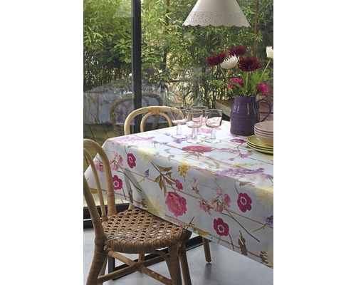 Eettafel met bloemendeken, glazen, servies en bloemen in vaas