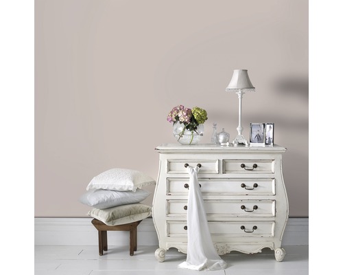 Decoratieve slaapkamer met commode, lamp en stapel kussens