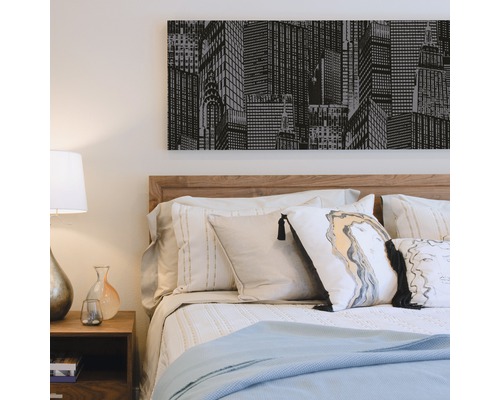 Slaapkamer met bed, nachtkastje en muurschildering