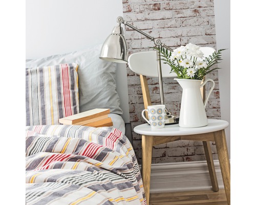 Decoratieve slaapkamer met bed, nachtkastje, lamp en bloemen
