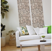 Woonkamer met steenbehang, bank en tafel voor een lichte sfeer.