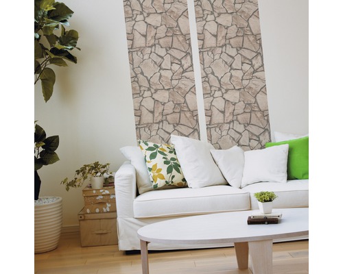 Woonkamer met steenbehang, bank en tafel voor een lichte sfeer.