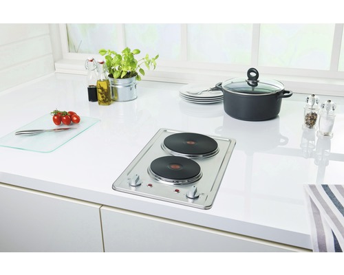 Keuken met dubbele kookplaat, pan, snijplank en kruiden