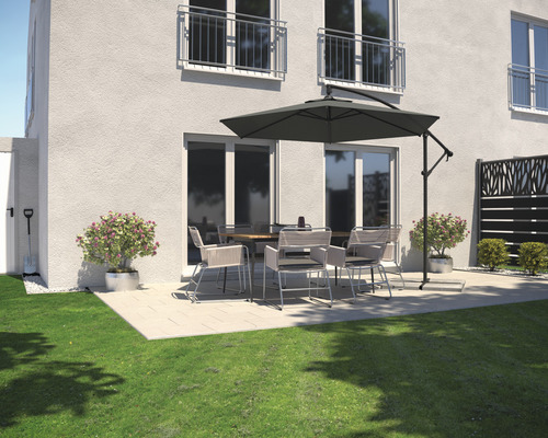 Terras met tuintafel, stoelen en parasol naast een woonhuis.