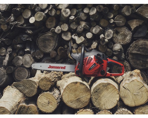 Jonsered kettingzaag op een stapel hout
