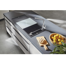 Spoelbak met snijplank, kraan, brood op snijplank en schaal met citroenen op een werkblad