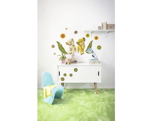 Kamerdecoratie met muurstickers van twee leeuwenfiguren, cirkels en bladeren boven een kast met pootafdrukstickers.