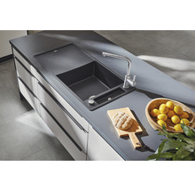 Spoelbak met kraan, snijplank, brood en citroenen op aanrecht