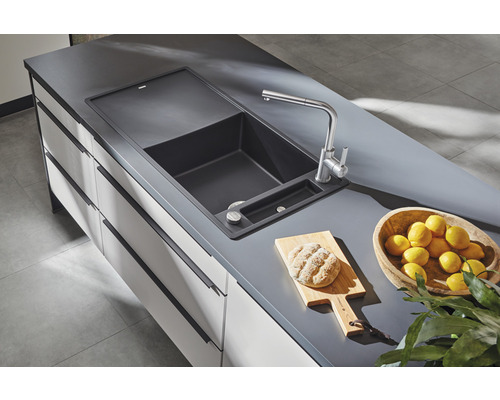 Spoelbak met kraan, snijplank, brood en citroenen op aanrecht