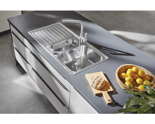 Roestvrijstalen spoelbak met afdruiprek en kraan op een aanrechtblad
