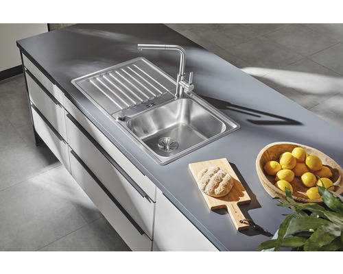 Roestvrijstalen spoelbak met afdruiprek en kraan op een aanrecht