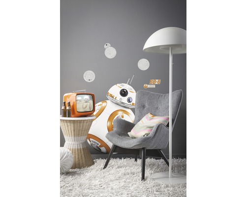 Decoratieve woonkamer met fauteuil, staande lamp, bijzettafel, televisie en Star Wars muurstickers.