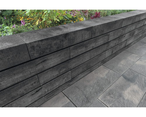 Tuinmuur gemaakt van betonstenen met bloembed