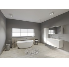 Badkamer met ligbad, wastafel, spiegelkast en plafondlampen