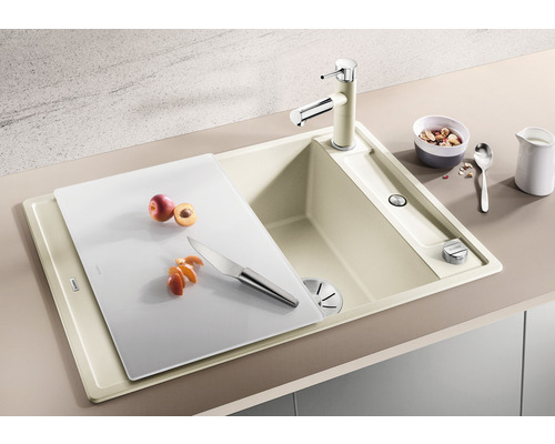 Spoelbak met snijplank, kraan, fruit en mes op een aanrecht