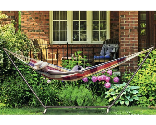 Persoon ontspant in een hangmat met frame in de tuin.