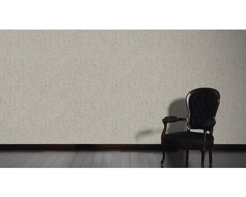 Lichtkleurig textielbehang in woonkamer met donkere houten vloer en stoel