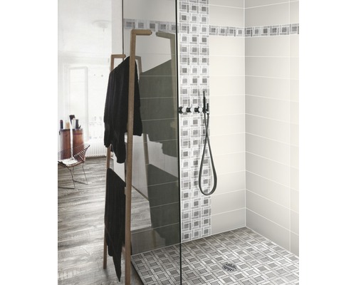 Inloopdouche met glazen wand, douchearmatuur en handdoekenrek in de badkamer.