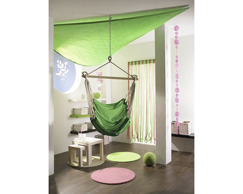 Licht ontworpen kamer met hangstoel, gekleurde tapijten en decoratieve elementen.