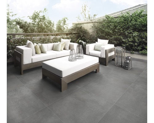 Terras met grijze tegels, bank, fauteuil en salontafel