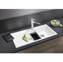 Spoelbak met afdruiprek, kraan en accessoires op een aanrecht.