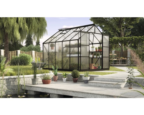 Kas met planten in een tuin met vijver