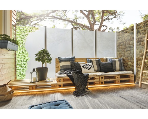 Terras met palletmeubilair, kussens, planten en privacyscherm