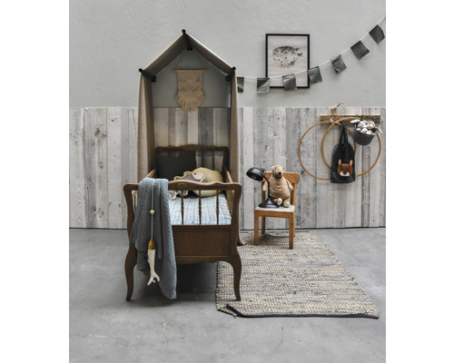 Kinderkamer met kinderbed met hemel, teddybeer op stoel en vloerkleed