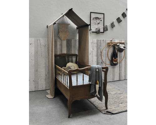 Kinderbed met hemel, kussens en decoratieve items in een kinderkamer