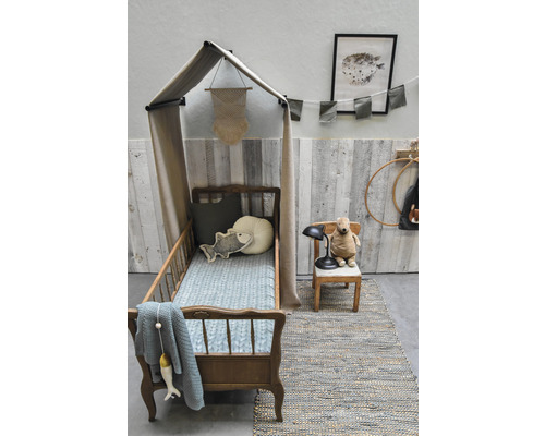 Kinderkamer met hemelbed, stoel en vloerkleed