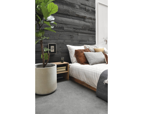 Slaapkamer met houten wandpanelen, bed en kamerplant in pot.