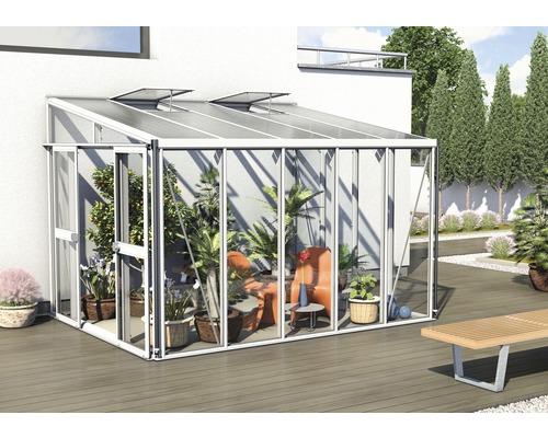 Kas met planten en zitplaatsen in de tuin.