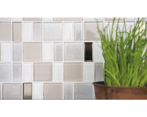 Detailopname van een wand met glazen mozaïektegels en decoratie