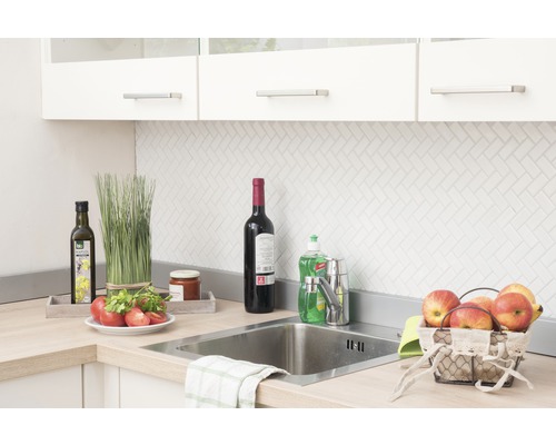 Keukenscène met gootsteen, kraan en diverse keukengerei op het aanrecht.